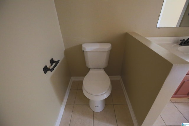 bathroom with toilet, vanity, baseboards, and tile patterned floors