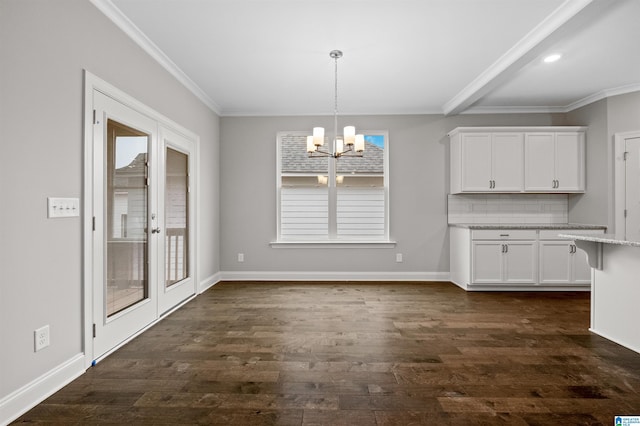 unfurnished dining area with dark wood-style floors, a notable chandelier, ornamental molding, and baseboards