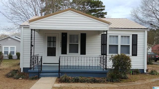 bungalow-style home with a porch and metal roof