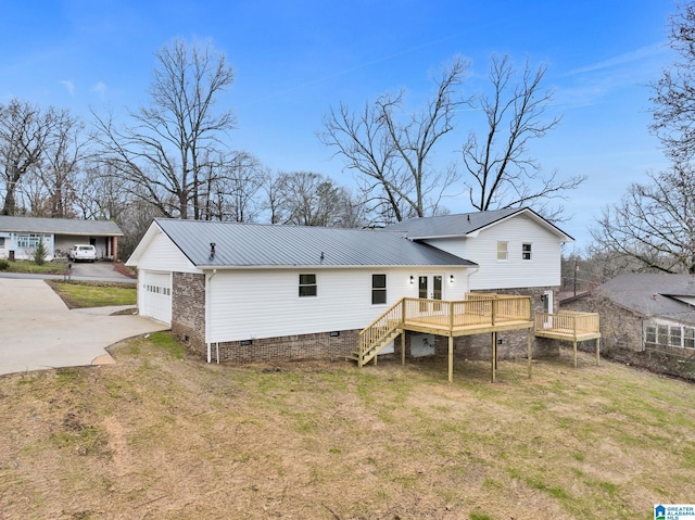 rear view of property featuring a lawn, crawl space, a deck, a garage, and stairs