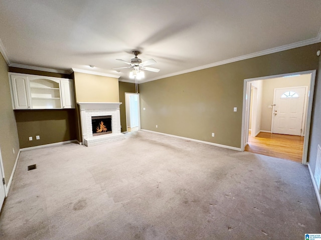 unfurnished living room with light carpet, a fireplace, visible vents, baseboards, and ornamental molding