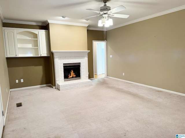 unfurnished living room featuring a brick fireplace, baseboards, crown molding, and light colored carpet