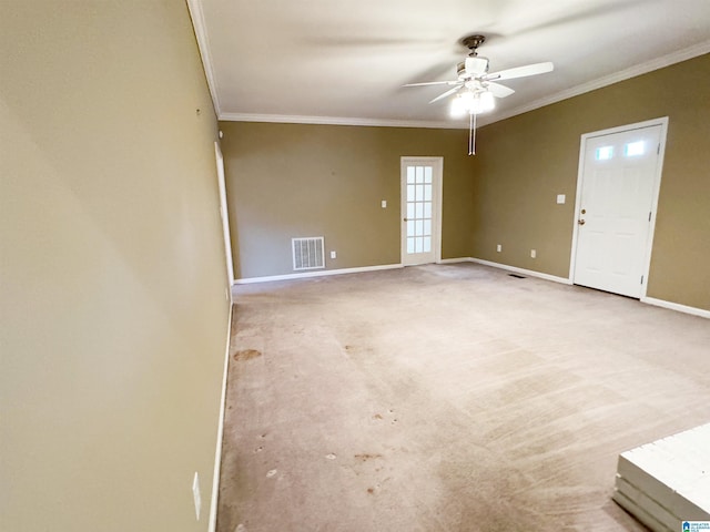 empty room with baseboards, ceiling fan, visible vents, and crown molding