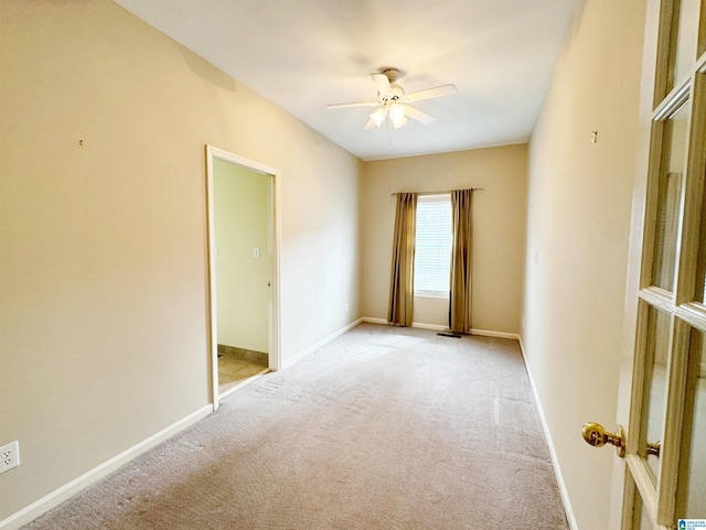 empty room with light carpet, ceiling fan, and baseboards