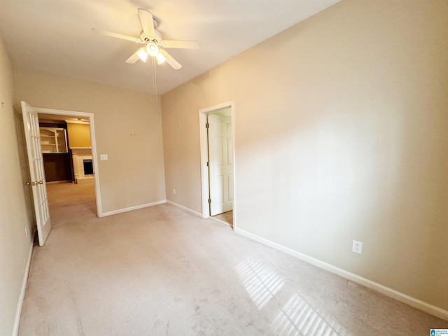 unfurnished bedroom featuring light carpet, ceiling fan, and baseboards