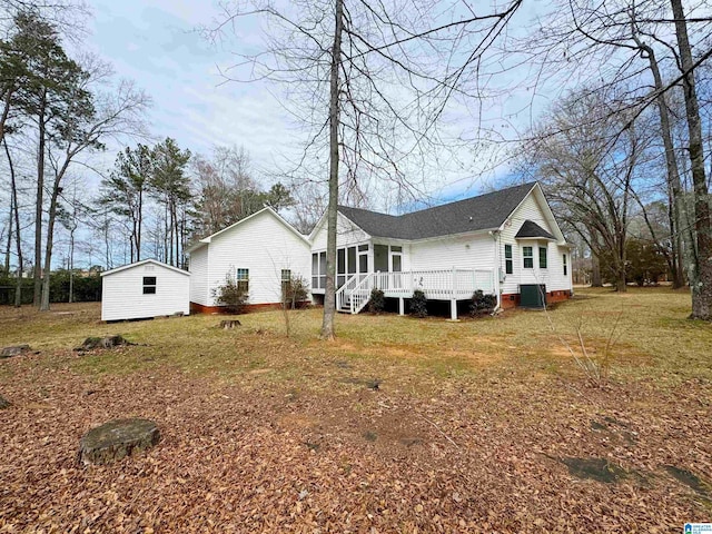 rear view of property featuring an outbuilding and central air condition unit