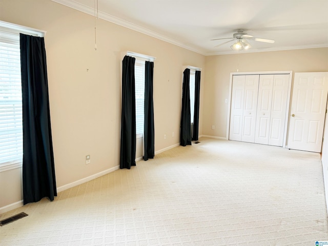 unfurnished bedroom with ornamental molding, light colored carpet, visible vents, and baseboards