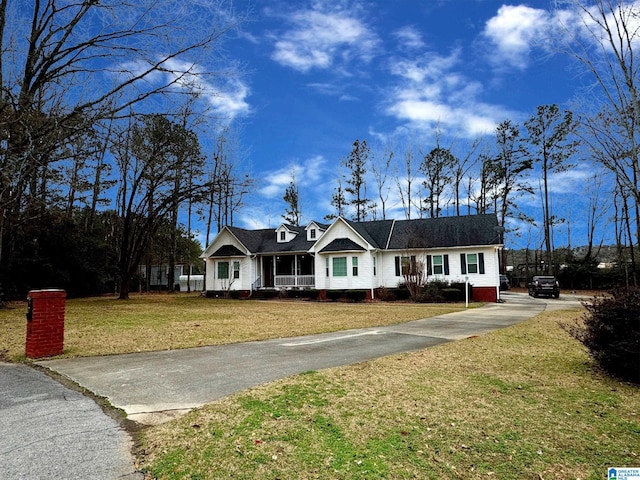 view of front of house featuring covered porch, concrete driveway, and a front yard