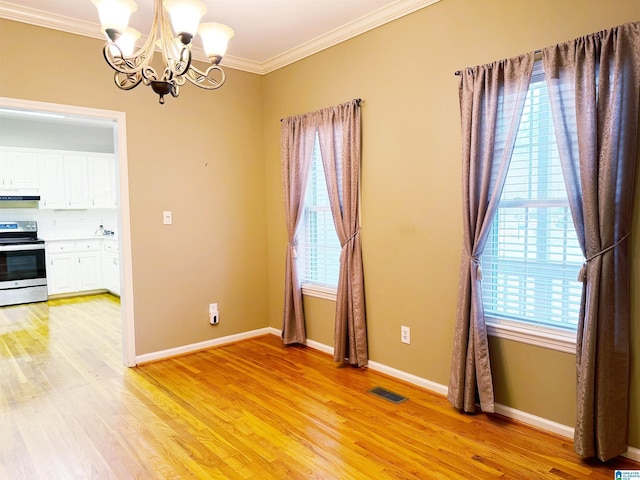 unfurnished dining area featuring a notable chandelier, visible vents, baseboards, ornamental molding, and light wood finished floors