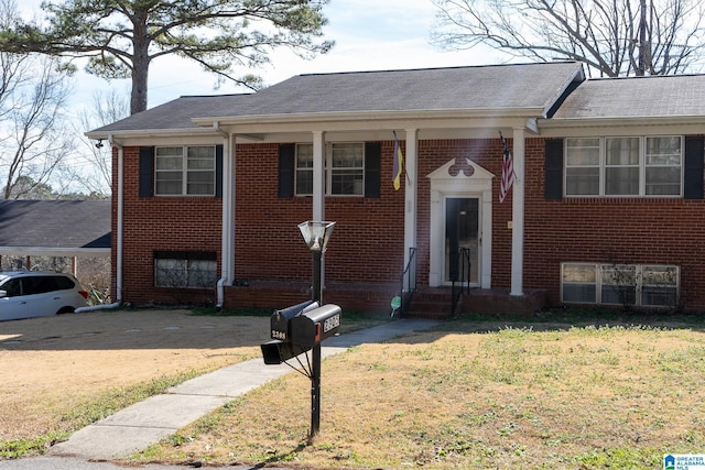 view of front of property with entry steps, brick siding, and a front lawn