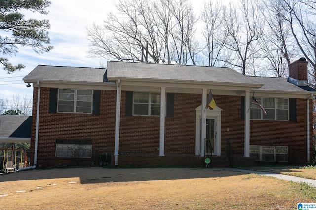 view of front of house featuring a chimney and brick siding