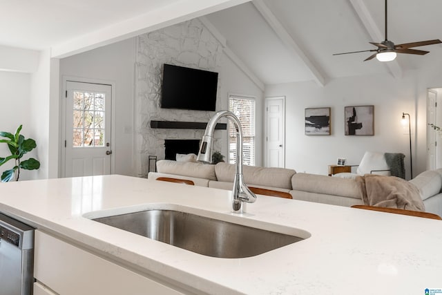 kitchen featuring a high end fireplace, open floor plan, a sink, and stainless steel dishwasher