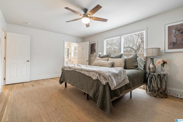 bedroom featuring light wood-type flooring, connected bathroom, baseboards, and ceiling fan