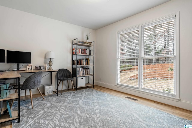 office space with visible vents, baseboards, and wood finished floors