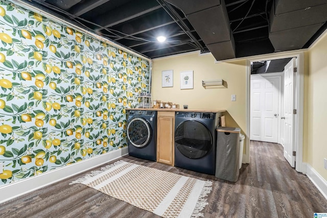 laundry area with laundry area, baseboards, dark wood-type flooring, and washing machine and clothes dryer