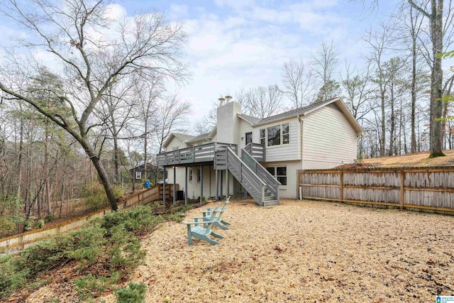 rear view of property with a chimney, stairway, fence, a deck, and brick siding