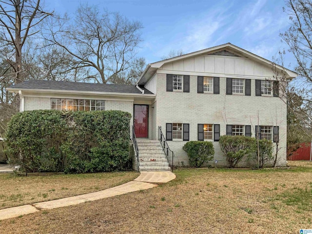 tri-level home with a front lawn, board and batten siding, and brick siding