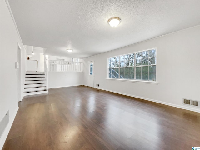 interior space featuring visible vents, stairway, dark wood-type flooring, a textured ceiling, and baseboards