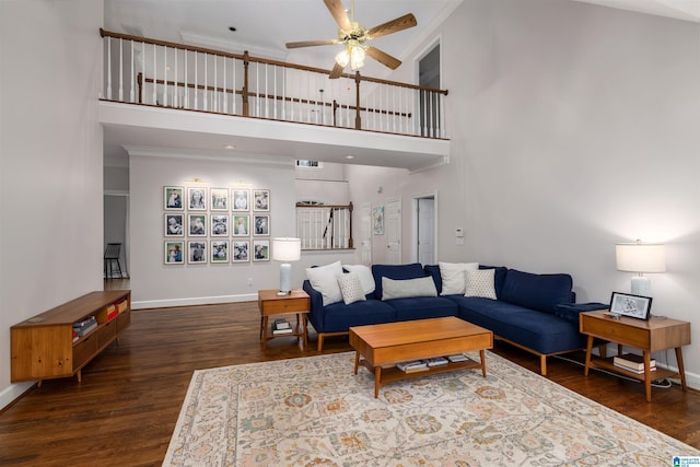 living area featuring dark wood-style floors, ceiling fan, ornamental molding, and baseboards