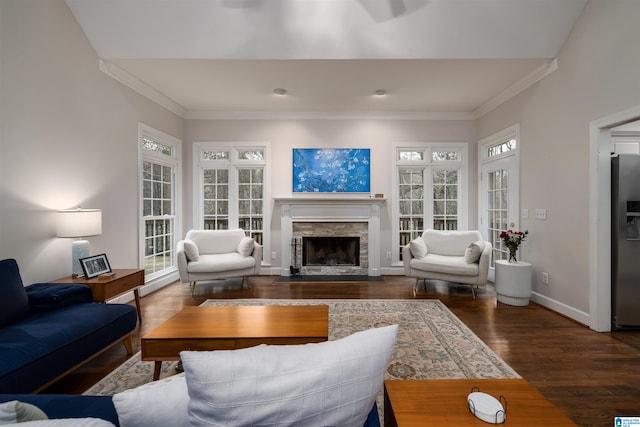 living area featuring dark wood-type flooring, a fireplace, crown molding, and baseboards