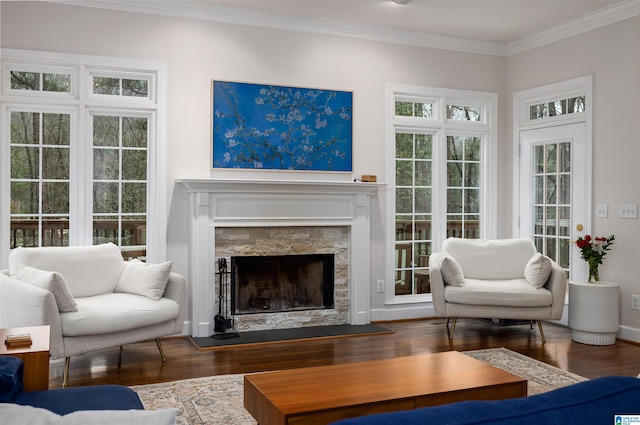 living room with dark wood-style flooring, a fireplace, crown molding, and baseboards