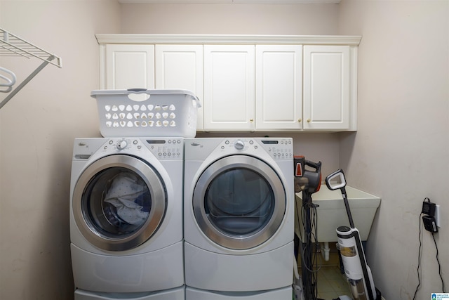 clothes washing area featuring independent washer and dryer and cabinet space