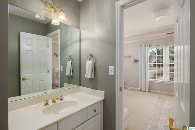 bathroom with ornamental molding, vanity, and baseboards