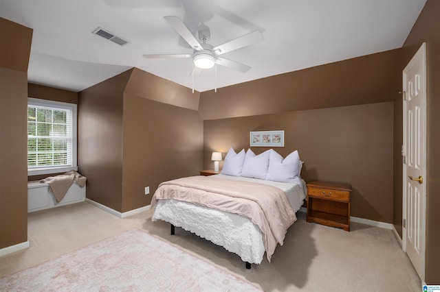 bedroom with light colored carpet, lofted ceiling, visible vents, and baseboards