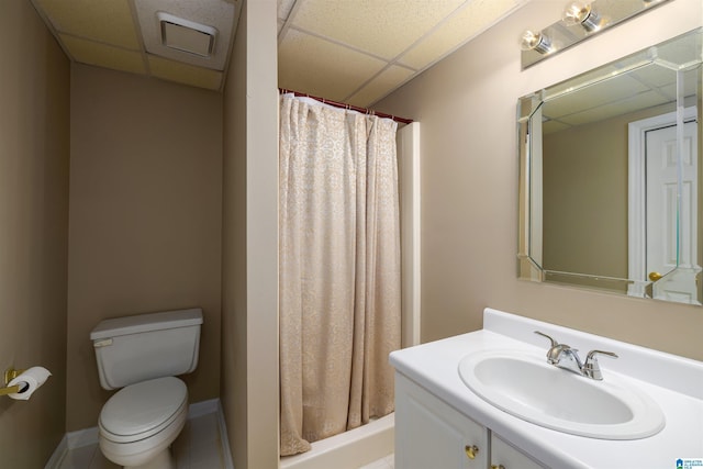 bathroom featuring a stall shower, baseboards, a drop ceiling, toilet, and vanity