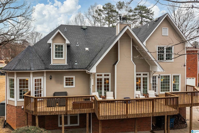 back of house featuring a chimney, a deck, central AC, and roof with shingles