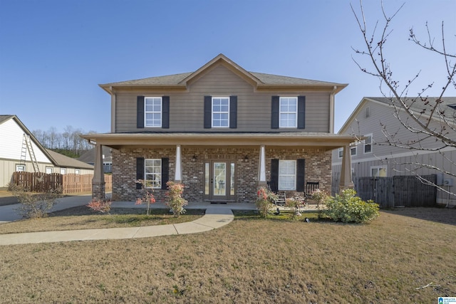 view of front of property featuring a porch, a front lawn, fence, and brick siding