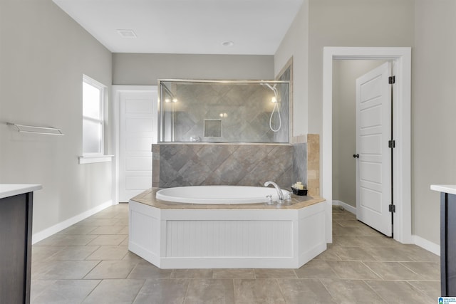 bathroom featuring a garden tub, baseboards, tiled shower, and tile patterned floors