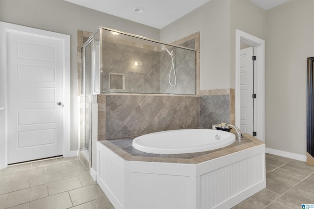 bathroom featuring tile patterned floors, a shower stall, and a bath