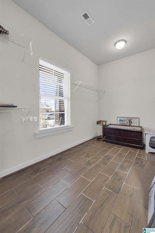 interior space featuring wood finish floors, visible vents, and baseboards