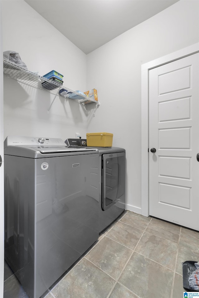 washroom with laundry area, baseboards, and washer and dryer