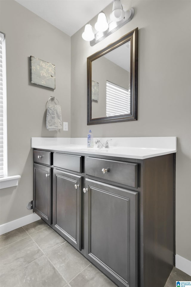 bathroom with tile patterned flooring, vanity, and baseboards