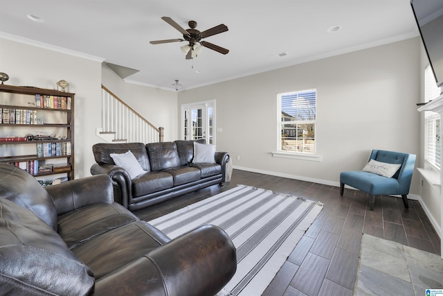 living area featuring crown molding, dark wood finished floors, stairway, ceiling fan, and baseboards