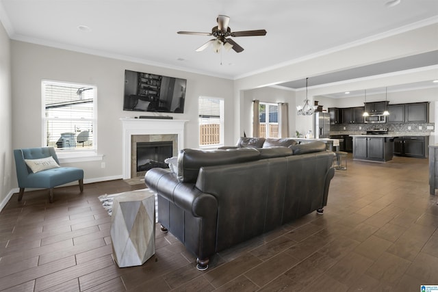 living room featuring ornamental molding, a fireplace, plenty of natural light, and baseboards