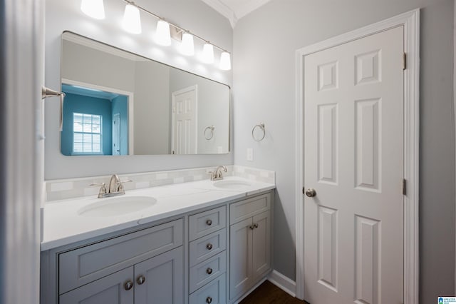 bathroom featuring double vanity, a sink, and crown molding