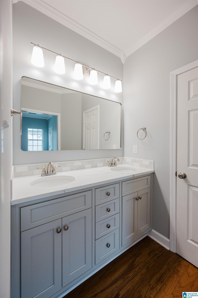 bathroom featuring double vanity, crown molding, a sink, and wood finished floors