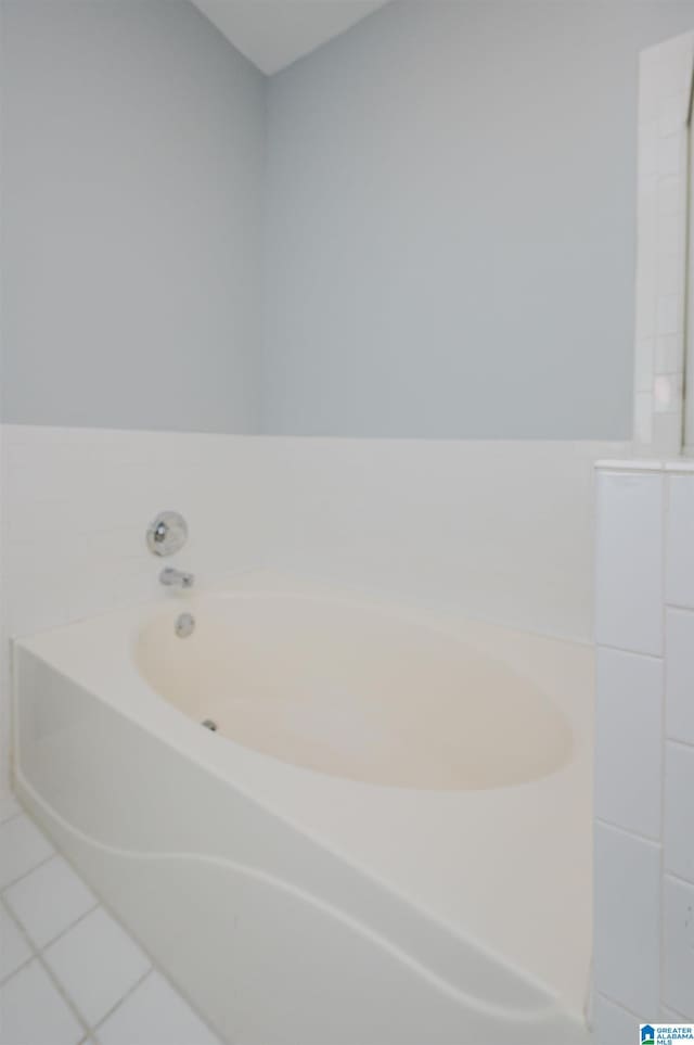 full bath with a garden tub and tile patterned flooring