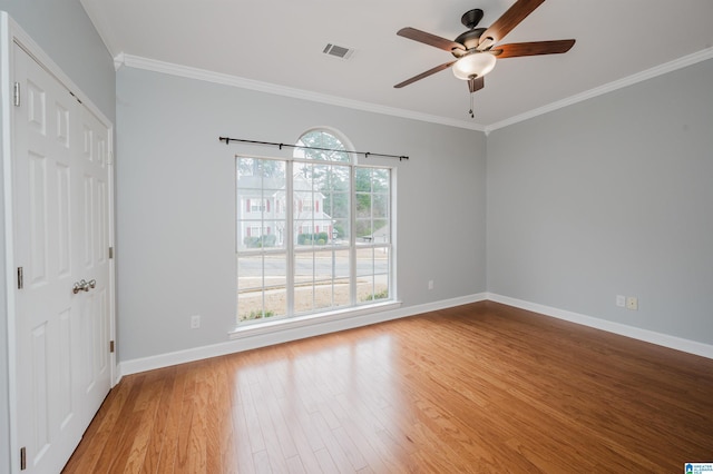 interior space featuring crown molding, a closet, baseboards, and wood finished floors