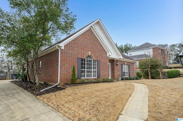 view of front of house featuring brick siding and a front lawn