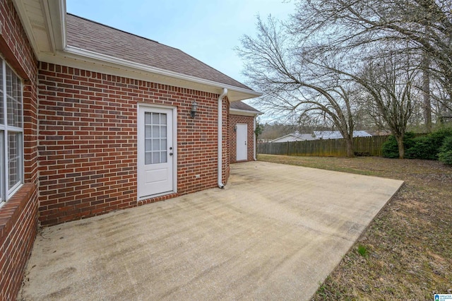 view of patio / terrace with concrete driveway and fence