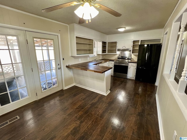 kitchen with open shelves, freestanding refrigerator, wood counters, stainless steel range with electric stovetop, and a peninsula