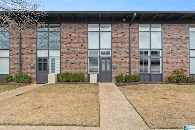 view of front facade with a front yard and brick siding