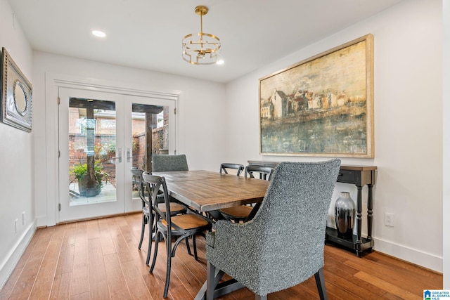 dining space featuring a notable chandelier, recessed lighting, wood finished floors, baseboards, and french doors