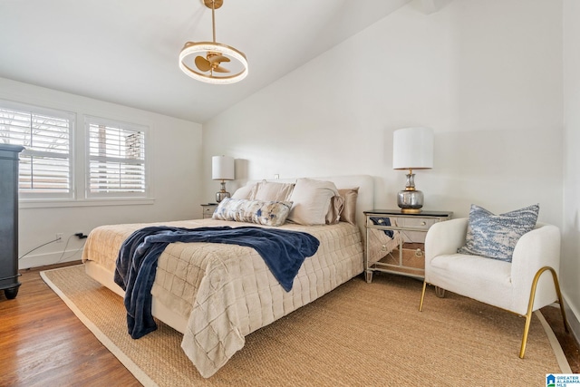 bedroom with vaulted ceiling and wood finished floors