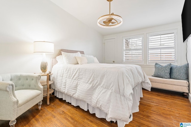 bedroom featuring dark wood-style floors and vaulted ceiling