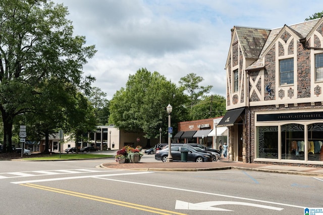 view of road with sidewalks, street lights, and curbs